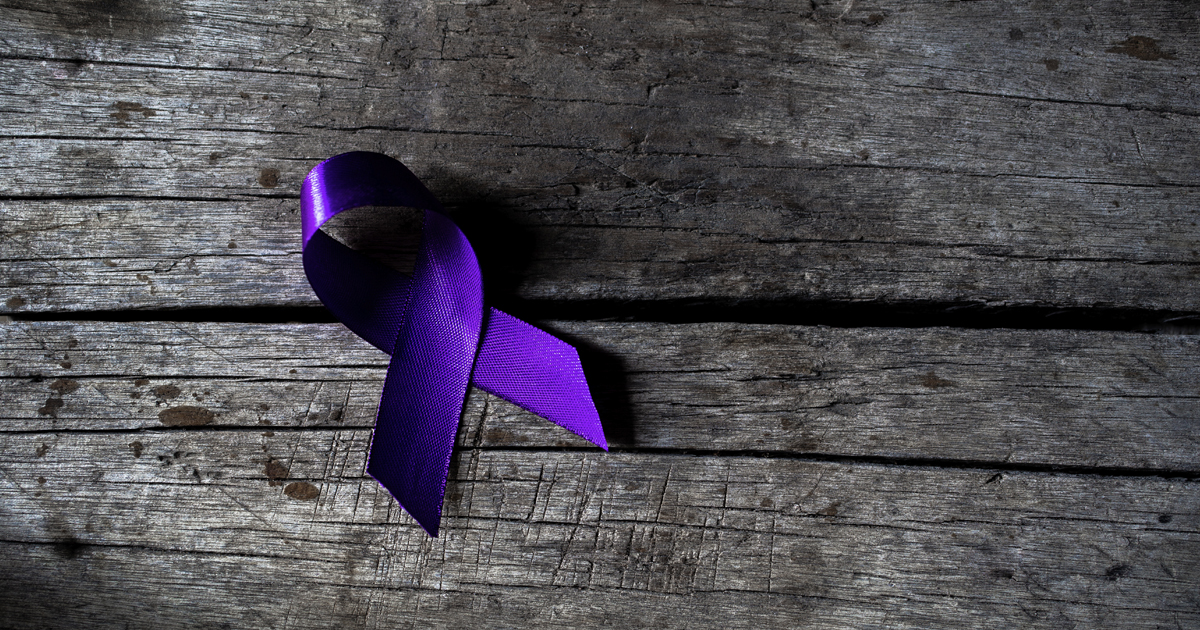 A purple ribbon on a wooden background